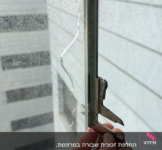 מדידת זכוכית עם קליבר ביד